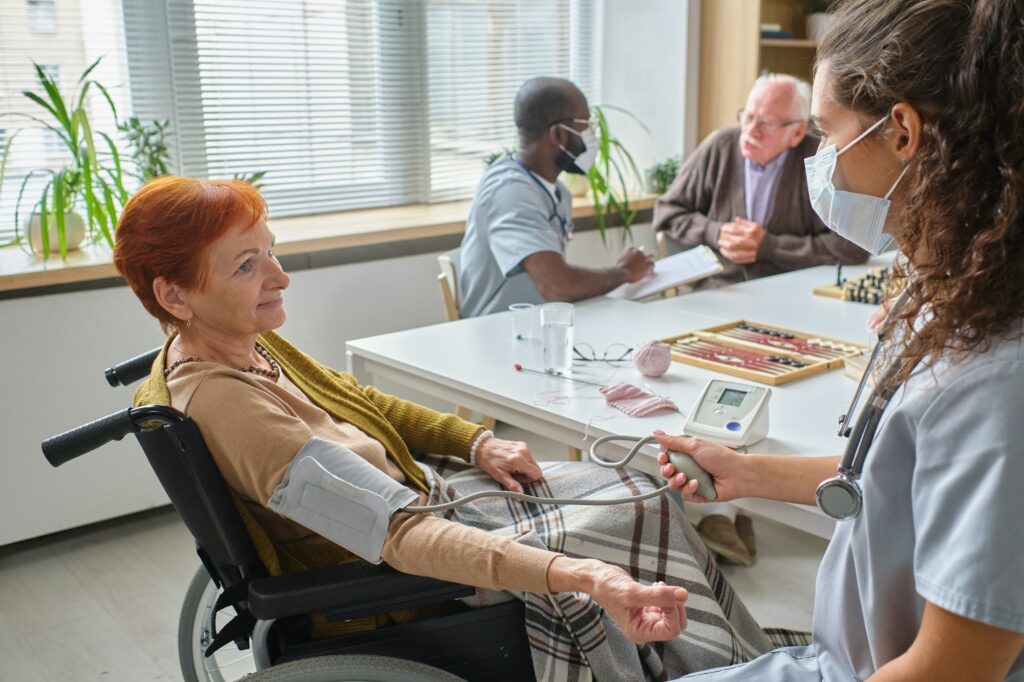 Nurse examining the elderly woman in nursing home